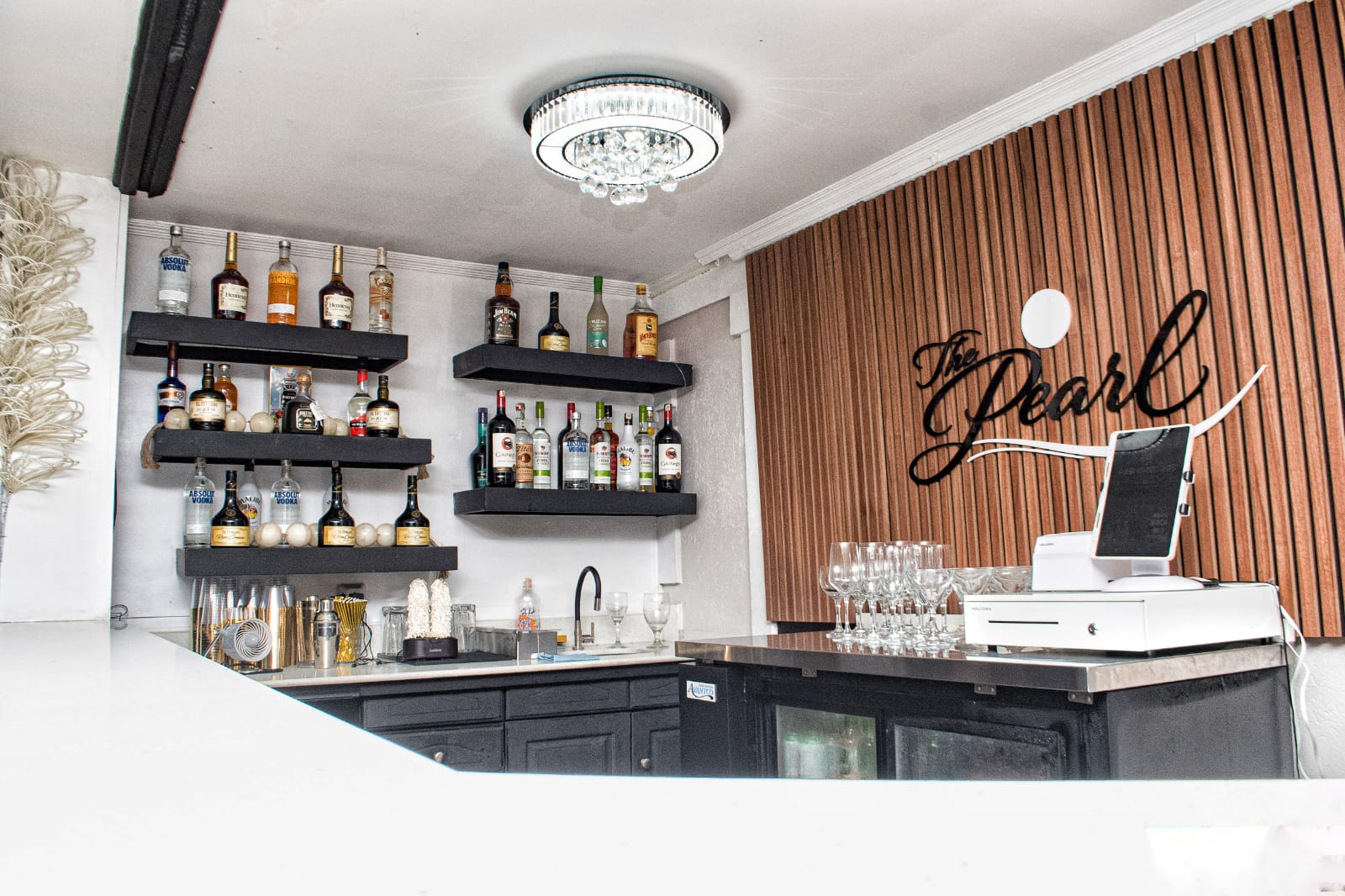The Pearl Bar interior with backlit shelves and signature logo